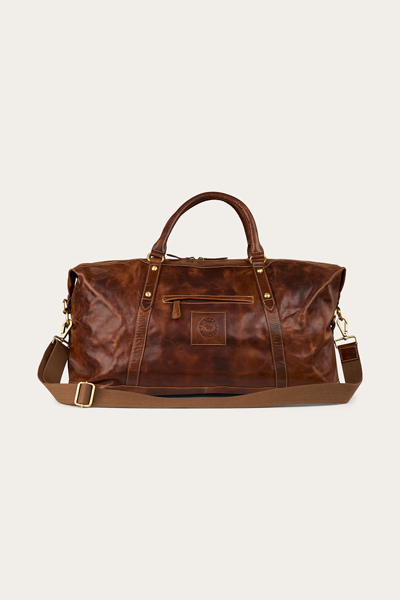 Brown leather bag with a strap on a light beige background
